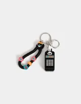 Llavero con dije de celular negro con teclado numérico y pantalla con la frase "Miss U". Incluye un strap de resorte negro con cuentas de colores y un dije con forma de cara.