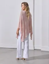 Poncho blanco de tejido calado con lurex, terminación asimétrica y cuello redondo.
