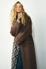 Trench color verde oscuro con cuello solapa combinado en pana marrón y manga larga. Detalle de acabados con trabillas y pinza en espalda. Bolsillos delanteros con solapa y botón a presión. Tejido encerado efecto lavado. Cierre frontal con botones a presión.