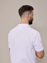Remera polo color beige, de piqué de algodón, con cuello clásico y tapeta de dos botones.