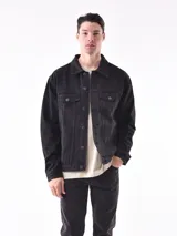 Campera de jean negra con botones metálicos, bolsillos frontales con solapa y cuello clásico.
