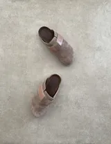 Suecos marrones de gamuza con hebilla lateral ajustable y suela de goma negra.