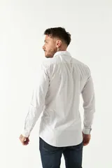 Camisa celeste a cuadros, de corte slim fit, manga larga y logo bordado. Confeccionada en 100% algodón.