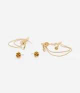 Ear cuff dorado asimétrico con caravana y cadenas colgantes, y caravana pequeña con forma de flor.
