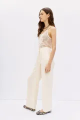 Pantalón palazzo de tiro alto, color negro, con caída fluida y largo al piso. Confeccionado en cupro y viscosa, presenta bolsillos laterales.