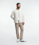 Camisa de hombre de corte regular, color borgoña, confeccionada en tela Oxford con efecto jaspeado. Tiene cuello inglés, abotonadura frontal, mangas largas con puños abotonados y bolsillo de parche en el pecho.