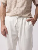 Pantalón de vestir blanco, de corte recto, con cintura elástica tipo jogger y bolsillos laterales.