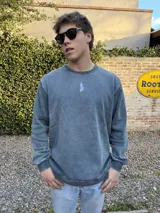 Buzo azul con efecto lavado, cuello redondo y logo bordado en el pecho.