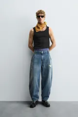 Pantalón de jean azul de corte amplio, con roturas y lavado gastado.