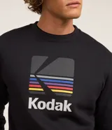 Buzo negro de algodón y poliéster con cuello redondo y mangas largas. Estampado frontal con el logo de Kodak a rayas de colores.