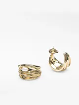 Pendientes tipo aro anchos de metal dorado con diseño acanalado y aplique de perla natural en el centro.