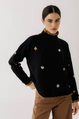 Sweater negro de punto con cuello alto y terminaciones acanaladas color marrón. Presenta bordados de tréboles en color beige.