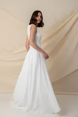 Vestido largo blanco de gasa, con corsé armado y falda con caída desde debajo del busto.