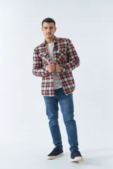 Sobrecamisa de algodón para hombre con interior de corderito, estampado a cuadros en tonos negro, blanco y azul. Tiene cierre de botones, bolsillos tipo cartera y logo en goma. El modelo usa talle M.