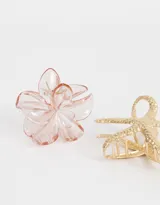 Set de dos broches para el pelo, uno dorado con forma de estrella de mar y otro transparente con forma de flor.