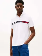 Chomba blanca de manga corta con cuello polo y tapeta de dos botones. Diseño con corte regular y logo de Tommy Hilfiger bordado en el pecho.