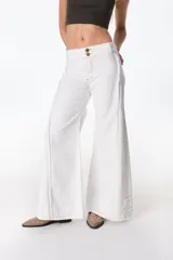 Pantalón jean blanco de corte acampanado, con cintura baja, dos botones dorados y costuras a la vista.