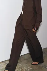 Pantalón marrón de tiro medio y pierna ancha, con cintura elástica ajustable con cordones.