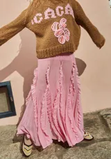 Falda midi de tul color rosa, con volados verticales y calce evasé. Tiene cintura elástica.