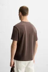 Camiseta marrón de punto de algodón, corte recto, cuello redondo y manga corta con terminaciones en rib.