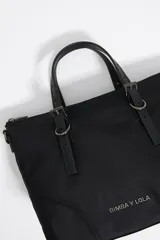 Bolso shopper de nylon color negro, con cierre de cremallera, asas de piel y tejido, y logo metálico en el exterior.