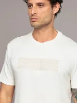 Remera blanca de algodón con logo de Calvin Klein texturizado en el pecho. Corte regular fit, manga corta y cuello redondo.