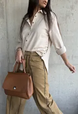 Camisa beige de lino con mangas 3/4 y cierre frontal con botones.