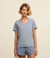 Remera deportiva de manga corta y escote en V, color azul claro, con detalles de costura en los hombros y un dobladillo inferior más grueso.
