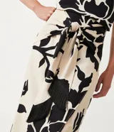 Pollera midi color beige con estampado floral negro, lazo en la cintura y tajo lateral.