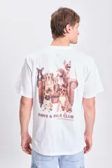 Camiseta blanca de corte amplio con estampa de perros sentados en un sillón y texto "Paws & Pals Club Genuine Connection".