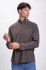 Camisa marrón de micropana con cuello abotonado, manga larga y bolsillo en el pecho.