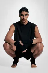 Musculosa deportiva negra sin mangas de punto suave con efecto lavado, corte holgado, cuello redondo ribeteado, bajo recto con aberturas laterales cortas y sisas sin rematar.
