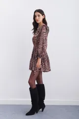 Vestido corto color marrón con estampado de cebra, escote en V, mangas largas con volados en los hombros y puños elásticos con volados.