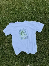 Remera blanca de algodón con estampa de un jarrón con flores en color verde.
