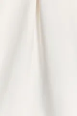 Vestido corto blanco de tejido elástico, con escote recto, tirantes finos ajustables, detalle de pliegues y cierre con cremallera oculta en la costura.