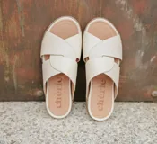 Sandalias de cuero color crema con tiras cruzadas y plantilla anatómica.