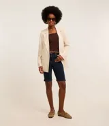 Bermuda femenina de jeans azul oscuro, modelo new ciclista, con trabillas en la cintura, bolsillos y cierre delantero con botón y cremallera.