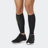 Medias de compresión para pantorrilla (calf guards) de color negro con detalles y logo en dorado. Presentan tecnología MCS para reducir la oscilación muscular.