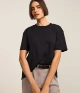 Blusa de mangas cortas confeccionada en algodón pima, con cuello redondo y bajo asimétrico.