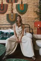 Chaleco negro de vestir, con escote en V y cierre frontal de botones dorados.