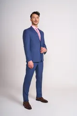 Traje azul de corte clásico, compuesto por saco de dos botones con solapa de muesca y pantalón de vestir con pinzas.