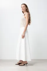 Maxi falda blanca de jean con corte evasé, cintura alta y cierre frontal con cremallera.