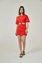 Vestido mini rojo de algodón, corte ajustado, con cuello redondo y detalle de nudo en la cintura con abertura en el abdomen.