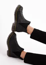 Botas de cuero negro con caña baja y elásticos en los laterales para un calce fácil, suela de goma antideslizante.
