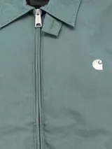 Campera azul con cuello camisero, cierre frontal con cremallera, bolsillos laterales y logo bordado en el pecho.