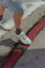 Zapatillas urbanas de cuero color crema con puntera y talón en gamuza gris, suela de goma marrón y cordones grises.