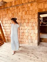 Vestido tejido color gris con hilado levemente brillante, corte oversized y flecos en el ruedo.