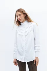 Camisa blanca de algodón con broderie y volados en cuello alto y puños.