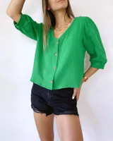 Blusa verde de muselina con mangas tres cuartos abullonadas y botones de madera.