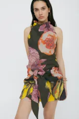 Minifalda estampada con flores en tonos rosa, amarillo, verde y negro. Presenta un lazo en la cintura para ajustar y cerrar la prenda.